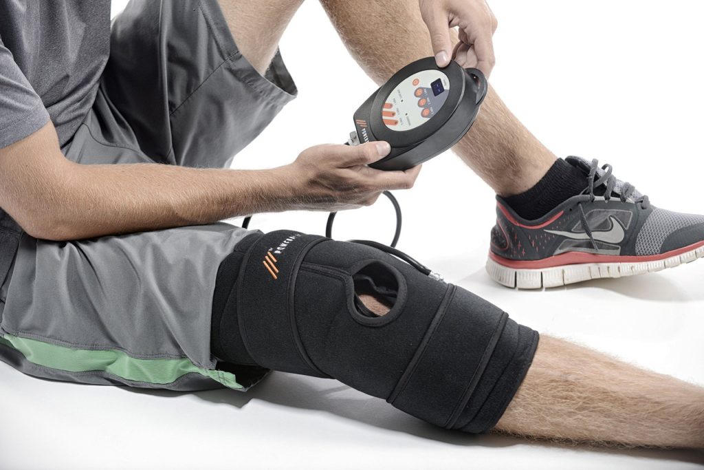 Man uses PowerPlay cold compression therapy device on knee